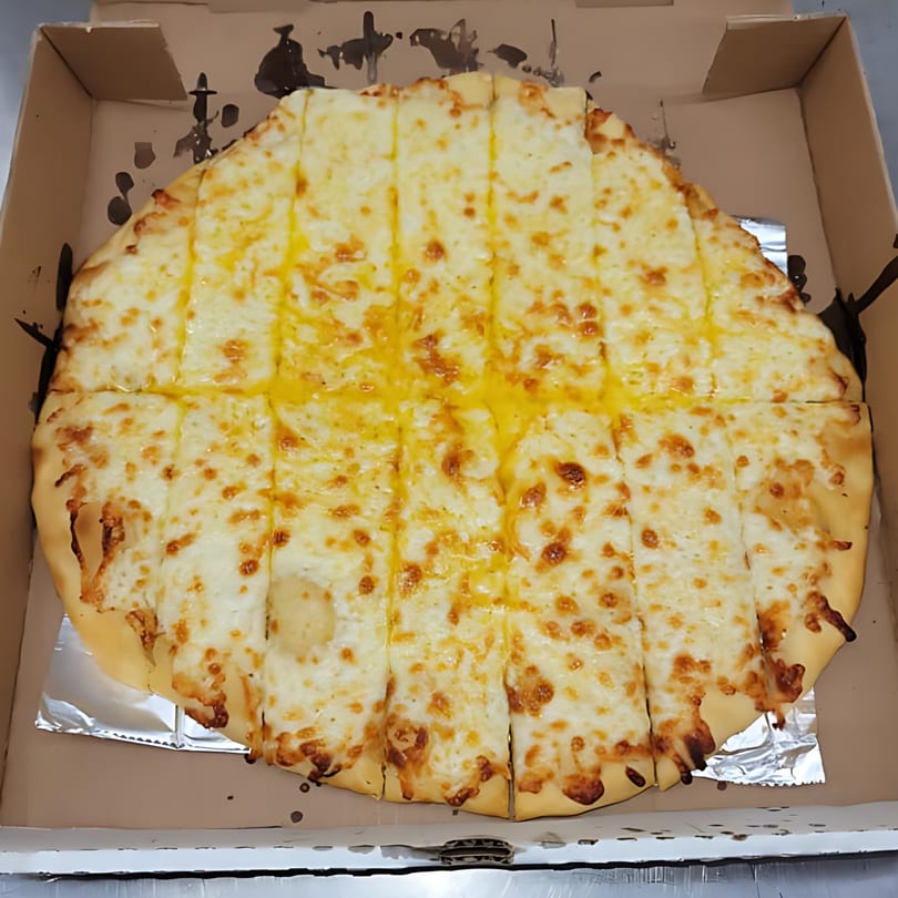 A Momo's Pizzeria cheese pizza, cut into strips, sits in a cardboard box.